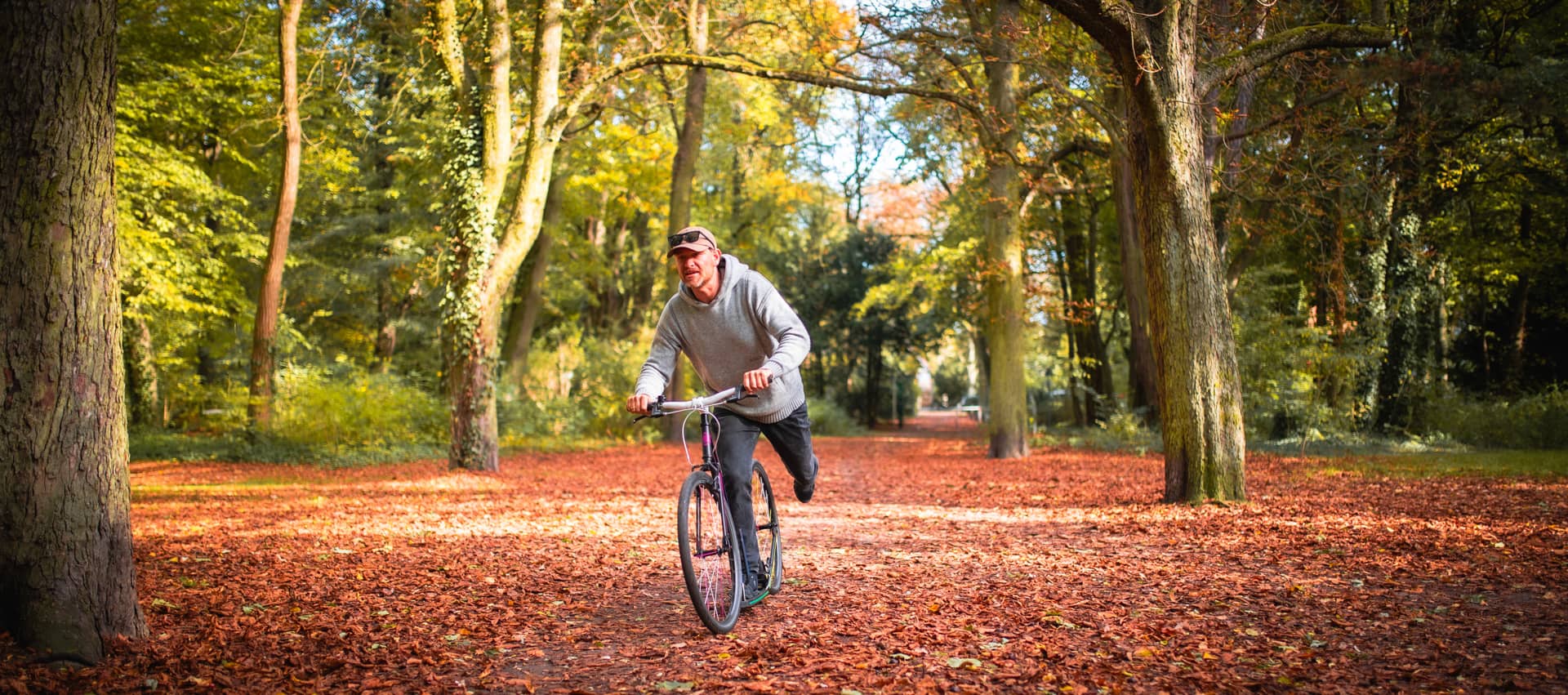 Tretroller fahrer im Herbstwald